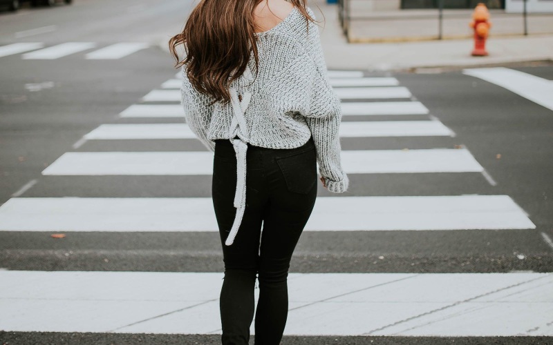 woman walking across a street